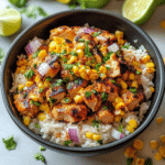 This Street Corn Chicken Rice Bowl combines grilled chicken, creamy corn, and fluffy rice for a delicious and easy meal! Try it today.